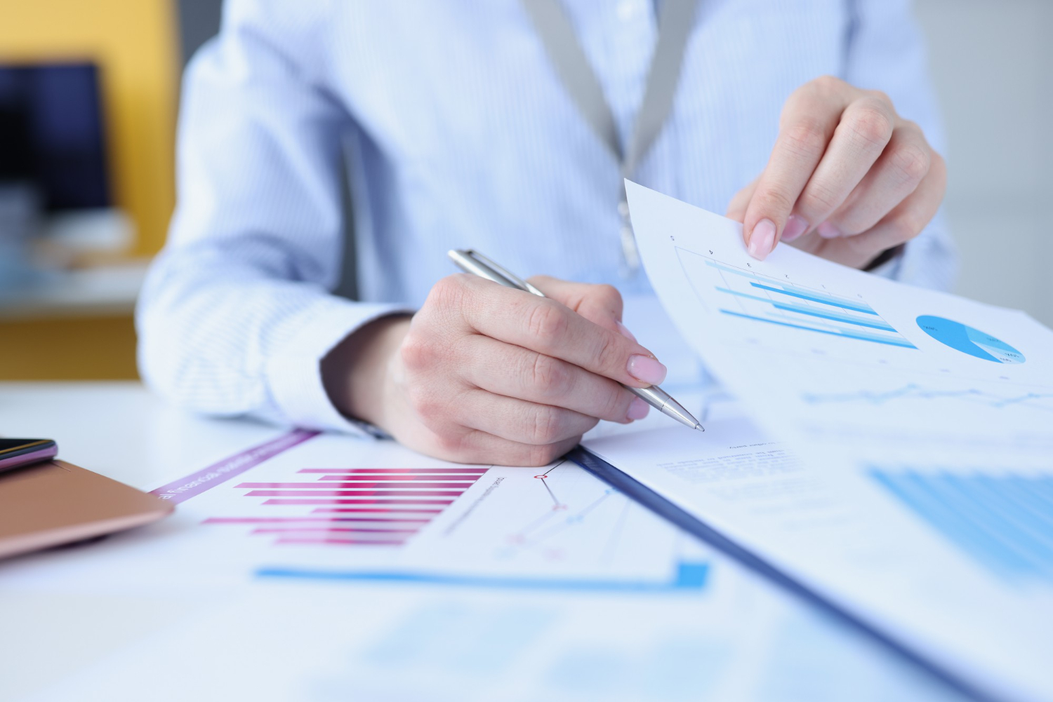 woman-signing-document-with-graphs-with-ballpoint-pen-closeup (1)
